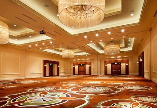 A view of the interior of the Mason Inn shows a large open room with many lit chandeliers.