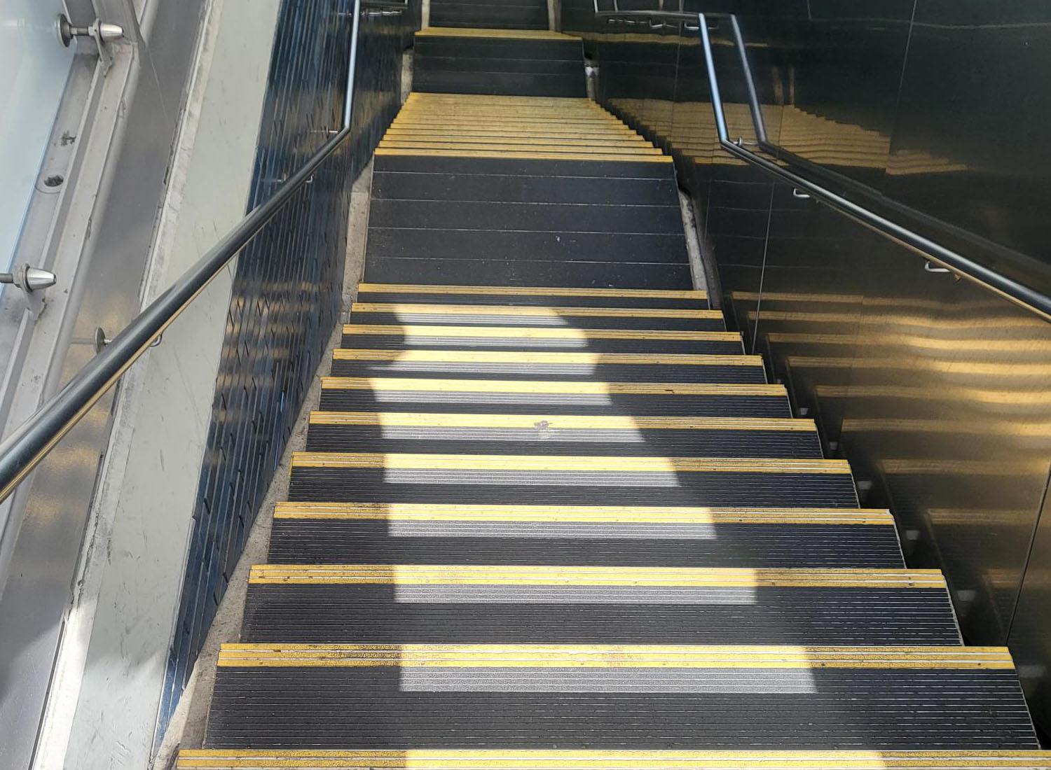 An overhead view of the Nystrom product; Renovation Abrasive Nosing, in use on a set of stairs.