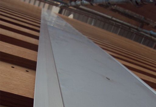 An up-close view of the Nystrom product, Expansion Joint, resting on brown colored planks.