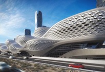 A wide exterior view of the Riyadh Metro is surrounded by tall city buildings and a few cars passing through.